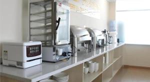 a kitchen with a counter with dishes and a coffee maker at City Comfort Inn Huizhou Zhongkai Huihuan in Huizhou +12 photos