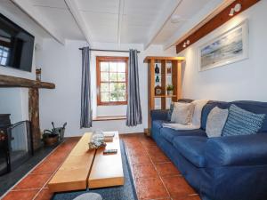 a living room with a blue couch and a coffee table at Rose Cottage in Falmouth