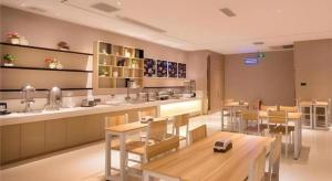 a restaurant with tables and chairs and a counter at City Comfort Inn Chongqing Jiangbei International Airport in Chongqing
