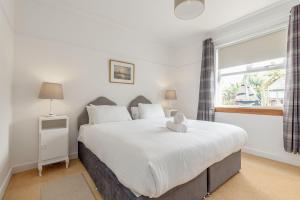 a bedroom with a large white bed with a window at Livingstone Crescent - No 5 in St. Andrews