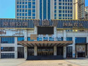 a building with a sign on it in front of buildings at James Joyce Coffetel· Changde Liuyehu in Changde