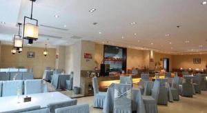 a restaurant with blue tables and chairs in a room at Lavande Hotels· Yueyang Linxiang Zhongfa in Linxiang