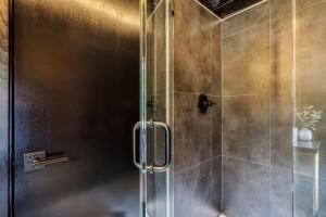 a shower with a glass door in a bathroom at Smoky Nook Soak and Smores Getaway in Cosby