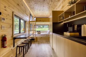 a kitchen with a counter and stools in a house at Smoky Nook Soak and Smores Getaway in Cosby