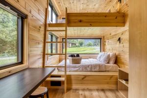 a tiny house with a bed and a window at Smoky Nook Soak and Smores Getaway in Cosby