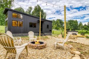 a group of chairs around a fire pit in front of a house at Smoky Nook Soak and Smores Getaway in Cosby