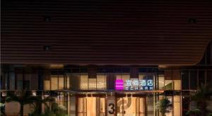 a building with a sign on the front of it at Echarm Hotel Nanning Wuxiang Headquarters Base in Nanning