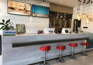 a bar with red stools in a lobby at City Comfort Inn Lhasa Gongga County Gongga Airport in Zamsar