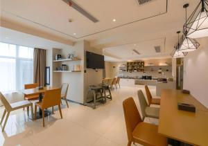 a living room with a table and chairs and a kitchen at City Comfort Inn Shiyan High-speed Railway Wanda Plaza in Shiyan
