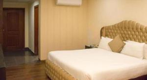 a bedroom with a large bed in a room at Hotel Grand Millennium in Lahore +10 photos