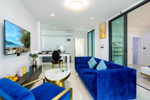 a living room with a blue couch and a table at New! bayfront 2 BR Villa with private pool Nariya V1 - rare find in Phuket in Ban Bang Chak