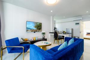 a living room with blue chairs and a table at New! bayfront 2 BR Villa with private pool Nariya V1 - rare find in Phuket in Ban Bang Chak