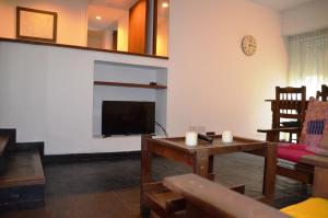 a living room with a flat screen tv and a table at De la calle 45 in La Plata