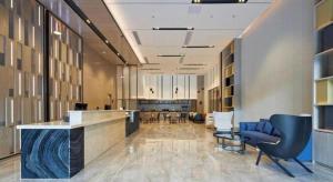 an office lobby with blue chairs and a reception desk at Echarm Hotel Liuzhou Yaobu Ancient Town in Liuzhou