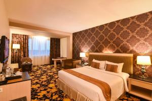 Postel nebo postele na pokoji v ubytování Grand Rocky Hotel Bukittinggi + 36 fotografií
