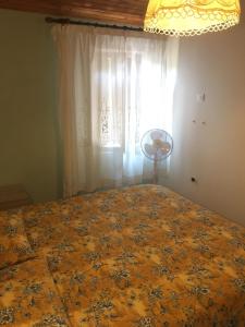 a bedroom with a bed and a window with a curtain at Chalet ValNevera in Primolano