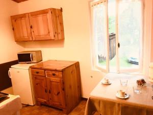 eine Küche mit Tisch und Mikrowelle und Fenster in der Unterkunft Chalet ValNevera in Arsiè