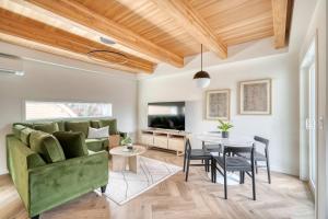 a living room with a green couch and a table at Stay Portland - Alberta Arts Escape - Modern 3BR Townhome in Portland