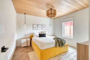 a bedroom with a yellow bed and a wooden ceiling at Stay Portland - Alberta Arts Escape - Modern 3BR Townhome in Portland