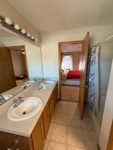 ein Badezimmer mit zwei Waschbecken und einem großen Spiegel in der Unterkunft Nice 3-bedroom house located in beautiful neighborhood in Lincoln + 40 Fotos