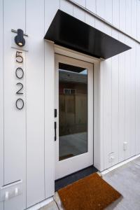 a door with a window on a white building at Stay Portland - Alberta Arts District Hideaway - Stylish Studio in Portland