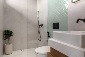 a bathroom with a shower and a toilet and a sink at Sunset Bliss Villa with Private Pool-North Canggu in Dalung +12 photos