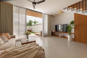 a living room with a couch and a tv at Sunset Bliss Villa with Private Pool-North Canggu in Dalung