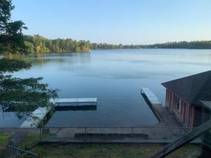 a view of a lake with a house and a dock at Private 6-Bdrm Lodge on 1000ft Sandy Lakeshore in Round Lake Seaplane Base