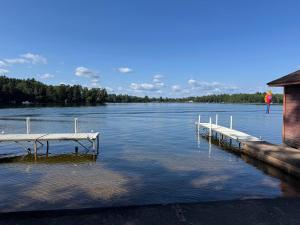 a dock in the water next to a building at Private 6-Bdrm Lodge on 1000ft Sandy Lakeshore in Round Lake Seaplane Base