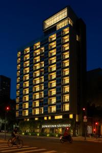 a man riding a bike in front of a building at Brás Downtown Residence Flat in Sao Paulo