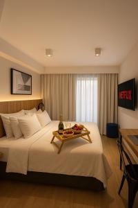 a hotel room with a bed with a tray of fruit on it at Brás Downtown Residence Flat in Sao Paulo