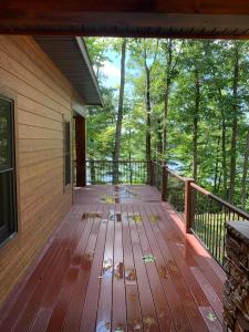 a wooden deck on a house with trees in the background at 5 Bdrm 12 Guest LakeHouse with Private Boat Dock in Round Lake Seaplane Base +13 photos
