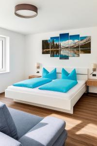 a white bedroom with a large bed with blue pillows at MOUNTAIN HOME apartment in Finkenberg