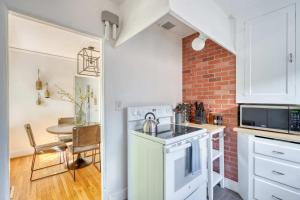een kleine keuken met een tafel en een bakstenen muur bij Cozy Boho 1BR - Walk to Shops & Cafes in Portland