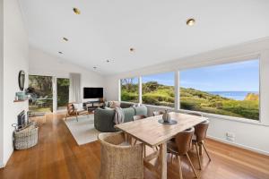 a living room with a table and a couch at Heath Cliff House in Aireys Inlet