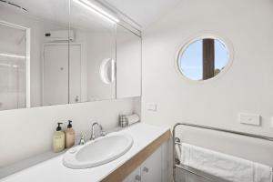 a white bathroom with a sink and a mirror at Heath Cliff House in Aireys Inlet +23 photos