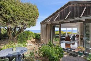 a wooden house with a patio and a table at Heath Cliff House in Aireys Inlet