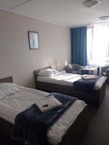 a hotel room with two beds and a chair at HOMER Bydgoszcz Ośrodek Rehabilitacji i Szkolenia PZN in Bydgoszcz +64 photos