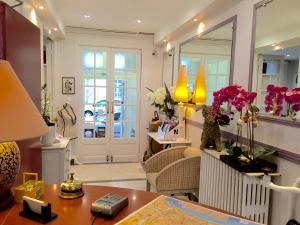 a living room filled with furniture and flowers at Hotel des Dames in Nice