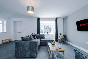 a living room with a couch and a table at 4 BDR House By Eason Stays Short Lets & Serviced Accommodation St Helens With Free Parking in Saint Helens