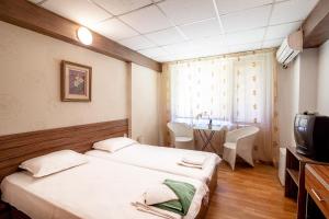 a hotel room with two beds and a table at Hotel Zara Rooms in Stara Zagora