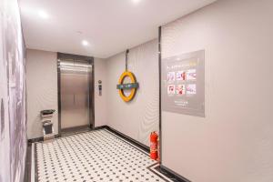 a bathroom with a shower with a clock on the wall at Premier City Comfort Hotel Yangzhou Shouxi Lake West Gate Weiyang Road Siji Garden in Yangzhou +121 photos