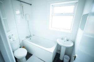 a white bathroom with a toilet and a sink at 3 BR House Near Beach By Eason Stays Short Lets & Serviced Accommodation Lowestoft in Lowestoft +23 photos