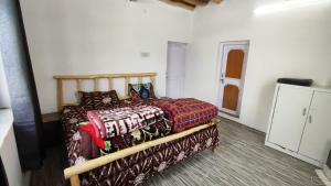 a bedroom with a wooden bed with blankets and pillows at Serenity Stay Rangrik in Kaza