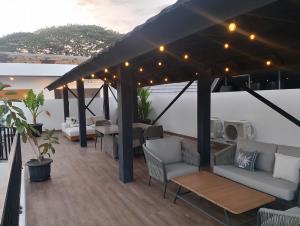 a pergola with couches and tables on a deck at Cassandra Villa 5 in Mantaak