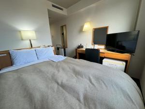 Una habitación de hotel con una cama y un escritorio con una computadora. en Ace Inn Matsusaka, en Matsusaka 38 fotos más