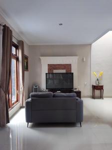 ein Wohnzimmer mit Couch und Flachbildfernseher in der Unterkunft Tropical Homestay of Balirejo in Demangan