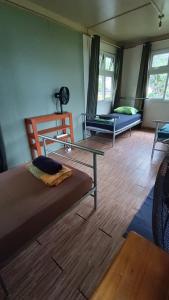 a room with two beds and a table and a couch at Moana at Teahupo'o in Teahupoo