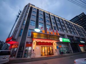 a large building on the corner of a street at Vienna Hotel Xuzhou Junsheng Plaza Benteng Avenue Metro Station in Xuzhou