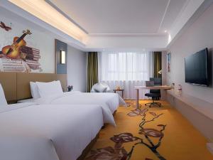 a hotel room with a large bed and a television at Vienna Hotel Xuzhou Junsheng Plaza Benteng Avenue Metro Station in Xuzhou